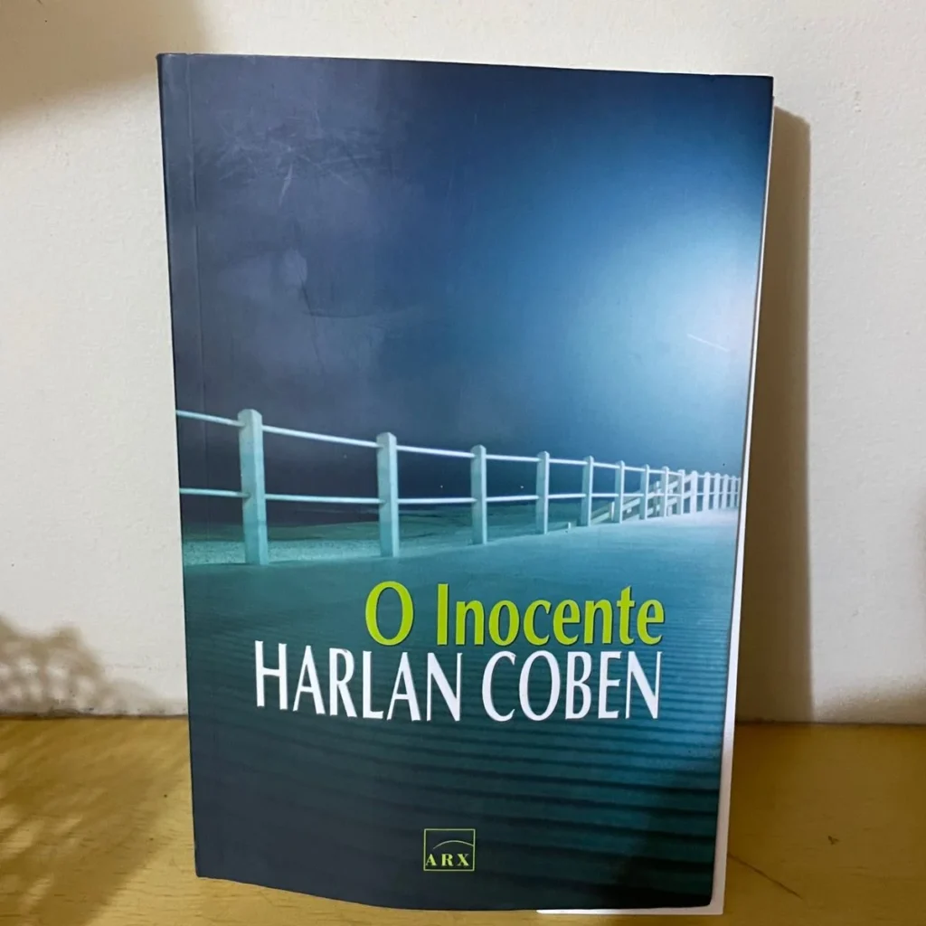 capa do livro original apoiado em uma parede, na capa tem a beirada de um ponta em tom azul noturno
